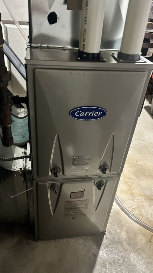 High-efficiency furnace installed in a townhome mechanical room, with new ductwork above