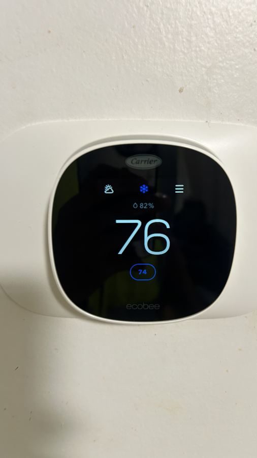 Smart thermostat mounted on a unit wall